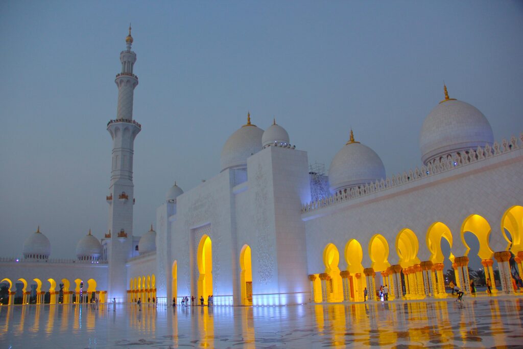 Sheikh Zayed Grand Mosque illuminated at twilight, showcasing stunning architecture in Abu Dhabi.