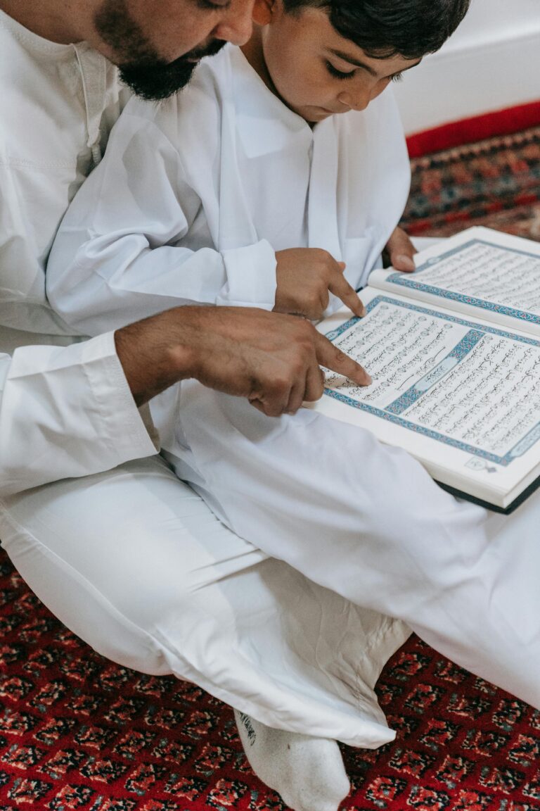 A father and son reading the Quran together, symbolizing faith and tradition.